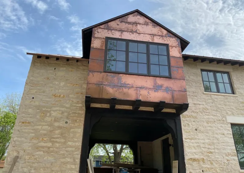 Copper metal panel facade on a stone building for Roof Repair in Florida Gulf Coast University